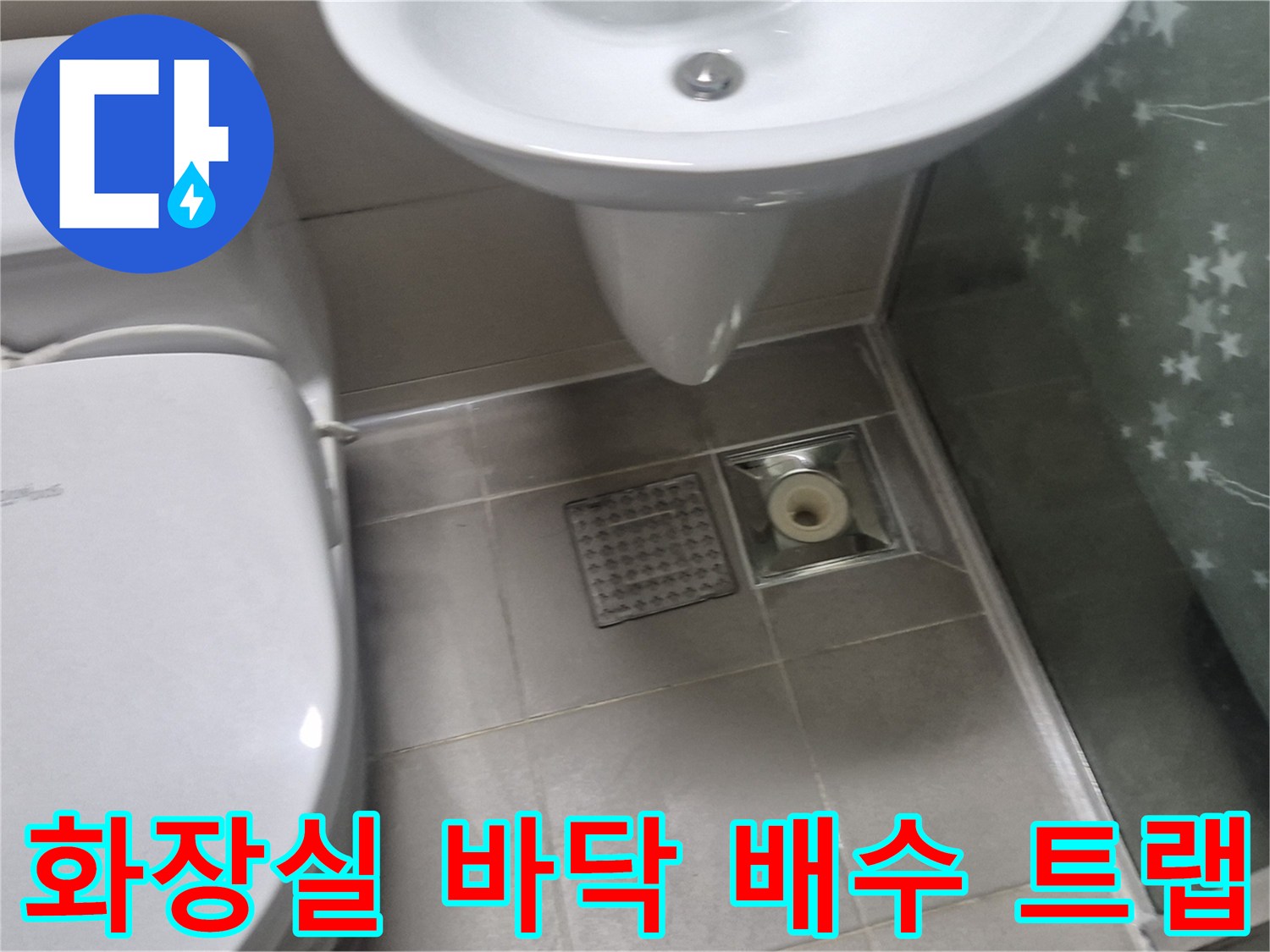 세면대 아래 설치된 욕실 배수구와 타일 마감 상태입니다.