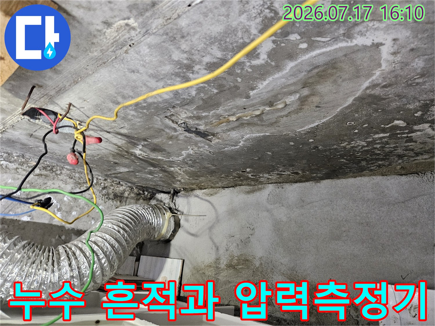 공압 측정 장비와 배관 연결부 및 누수 얼룩이 있는 천장 부위