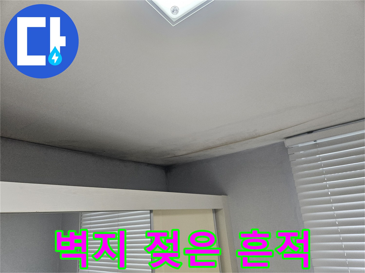 아파트 거실 천장 벽지가 습기로 인해 어둡게 변한 모습입니다.
