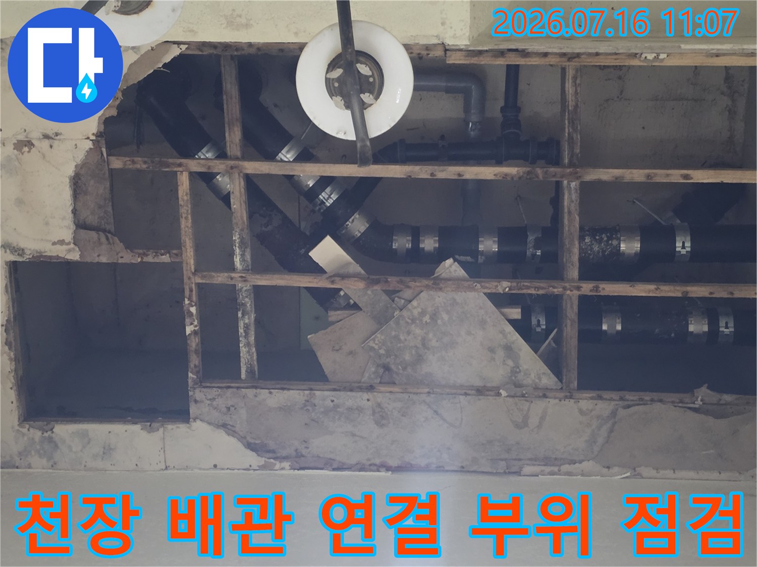 천장 내부 노출된 배관과 소켓 연결 부위를 정밀하게 점검하는 모습