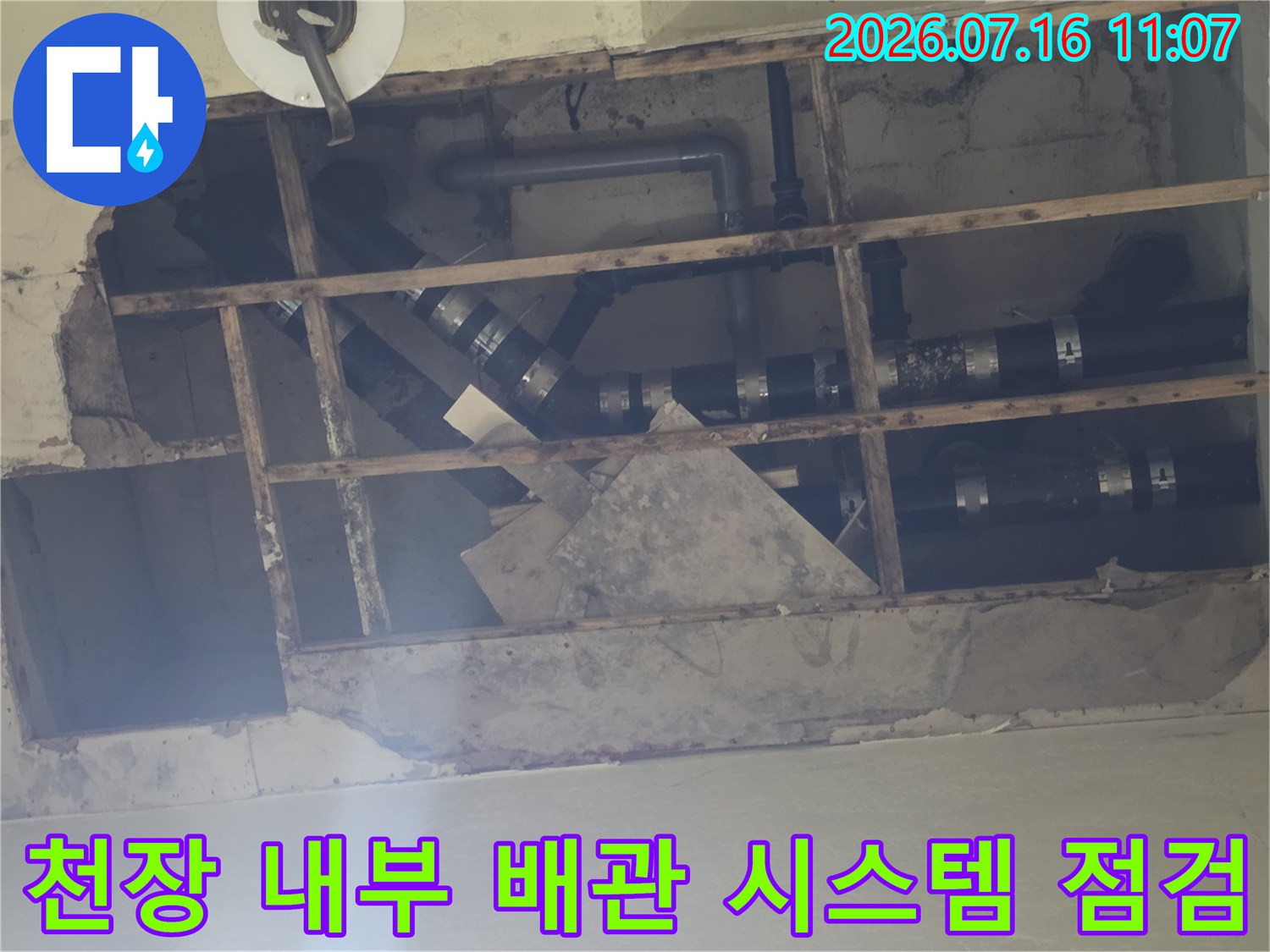 천장 안쪽의 복잡한 배관 연결부와 누수 지점을 확인하는 공사 현장