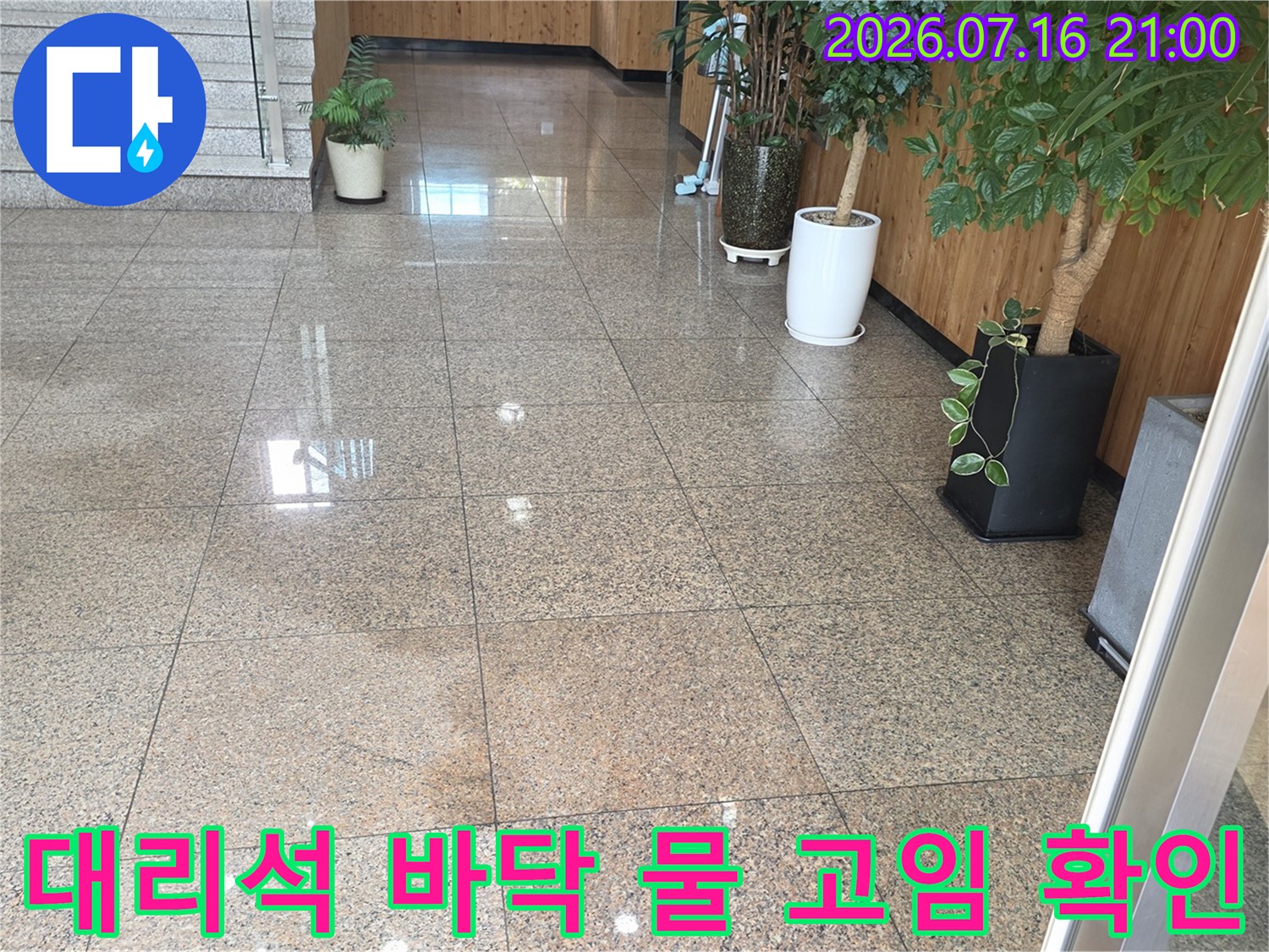 로비 대리석 타일 위 누수로 인한 수분 번짐을 기록한 사진