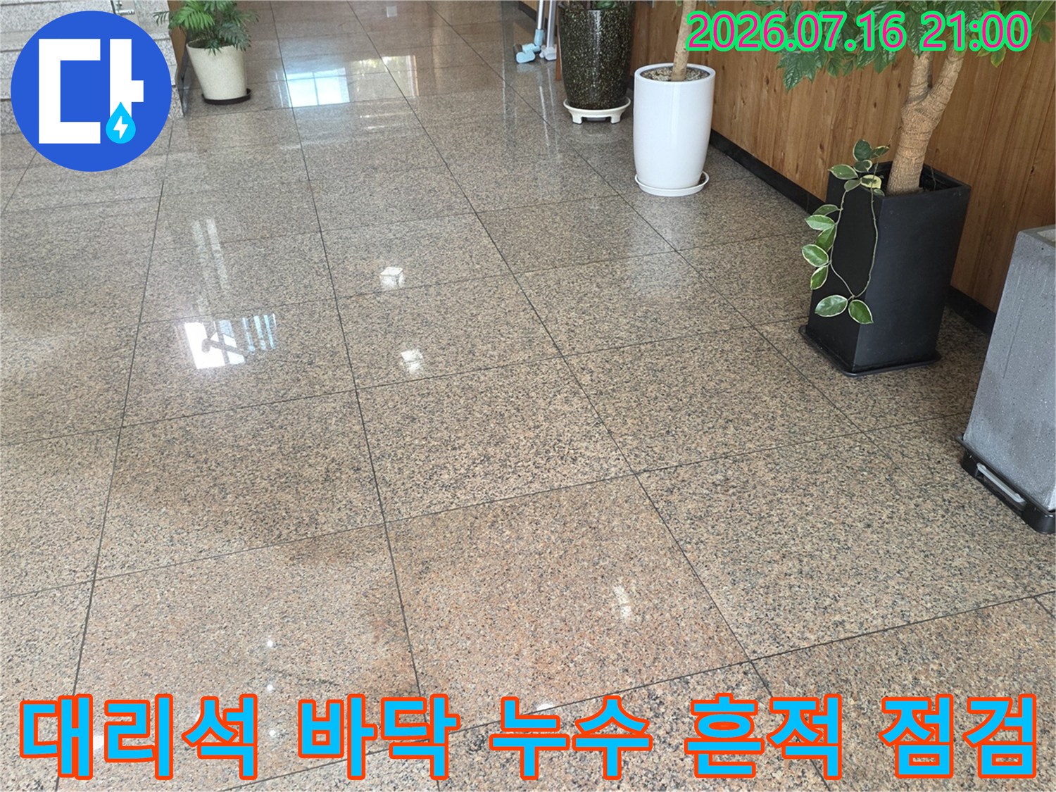로비 입구 대리석 타일 위 물번짐 현상 및 주변 시설물