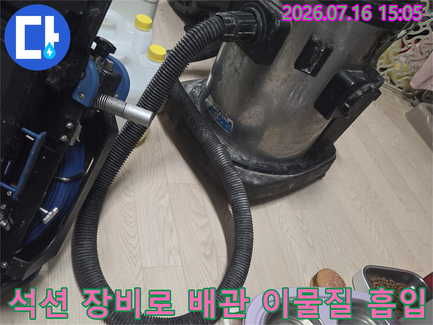 싱크대 하수관의 슬러지를 제거하기 위해 석션기 호스를 연결한 장면