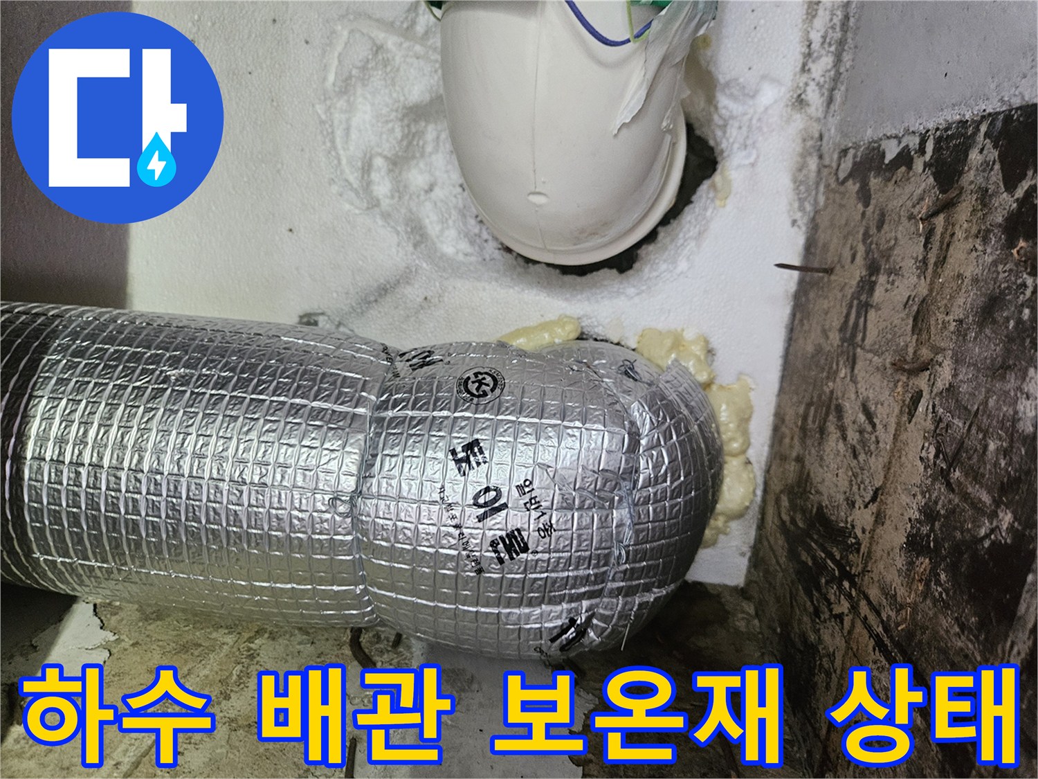 은박 보온재로 감싸진 하수 배관과 주변의 우레탄 폼 마감 부위