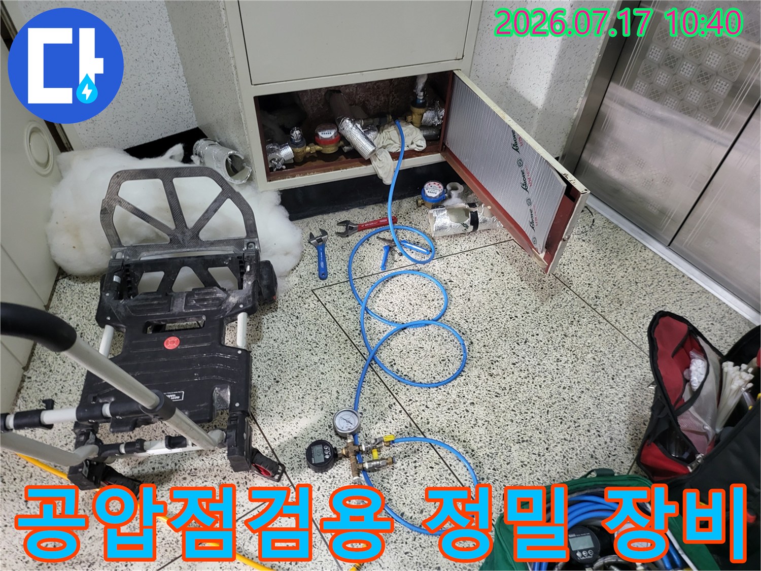 파란색 호스와 압력 게이지가 연결된 누수 탐지 전문 장비