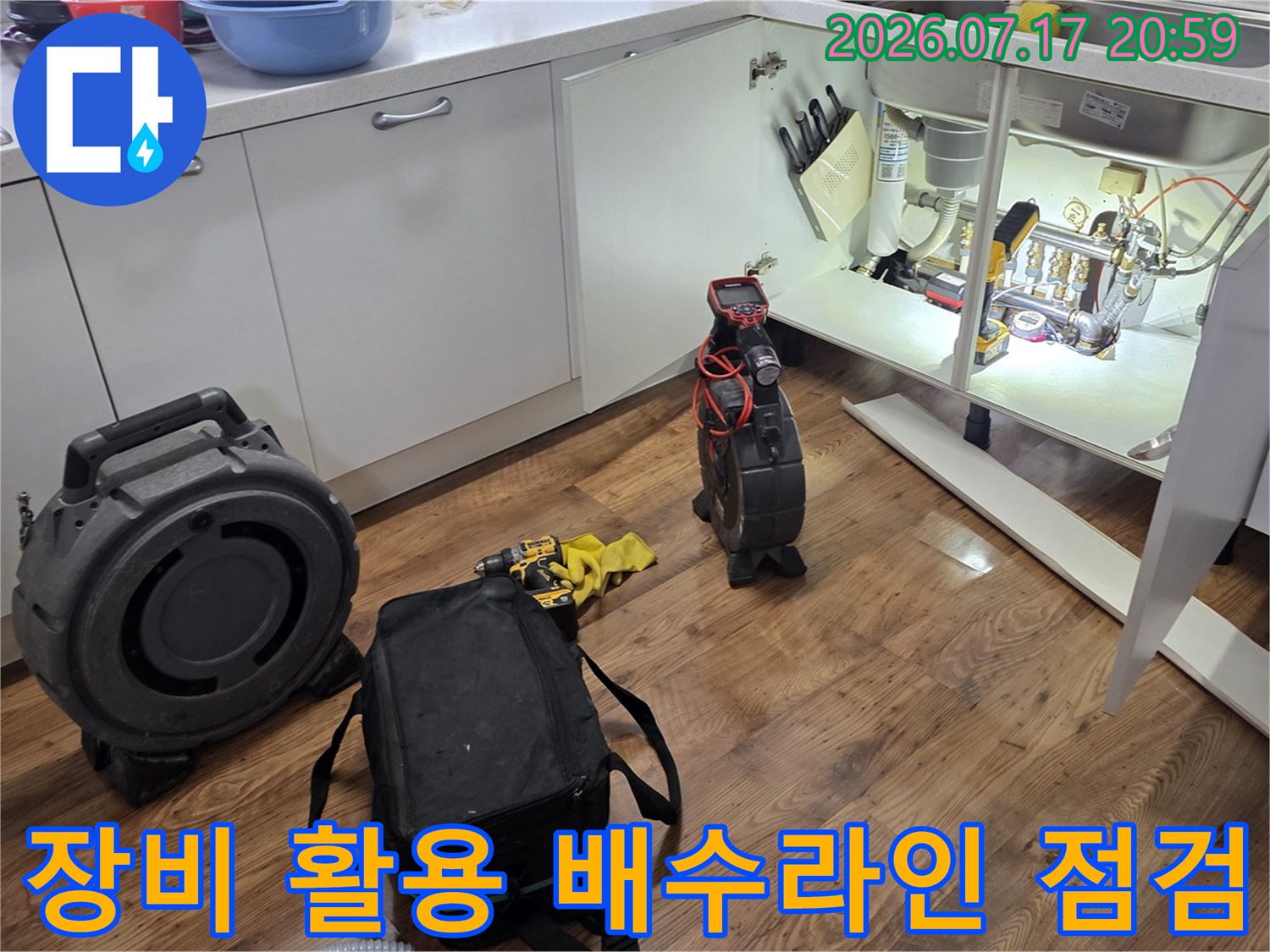 싱크대 밑에 위치한 가스 탐지기와 청음기를 배치하여 배관의 이상 여부를 체크하는 장면