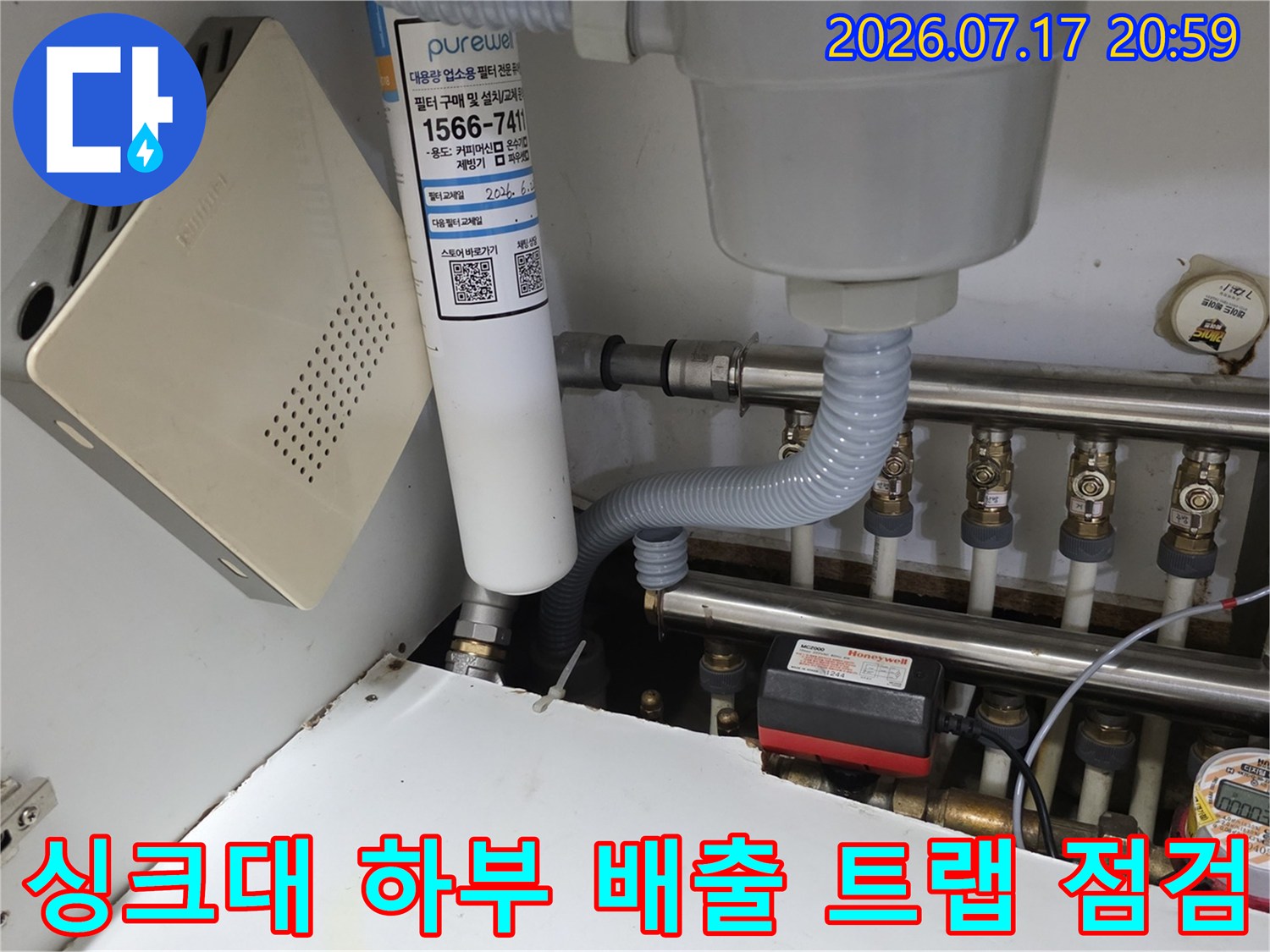 싱크대 밑에 위치한 여러 개의 파이프와 밸브들 중 누수 의심 부위를 정밀 확인