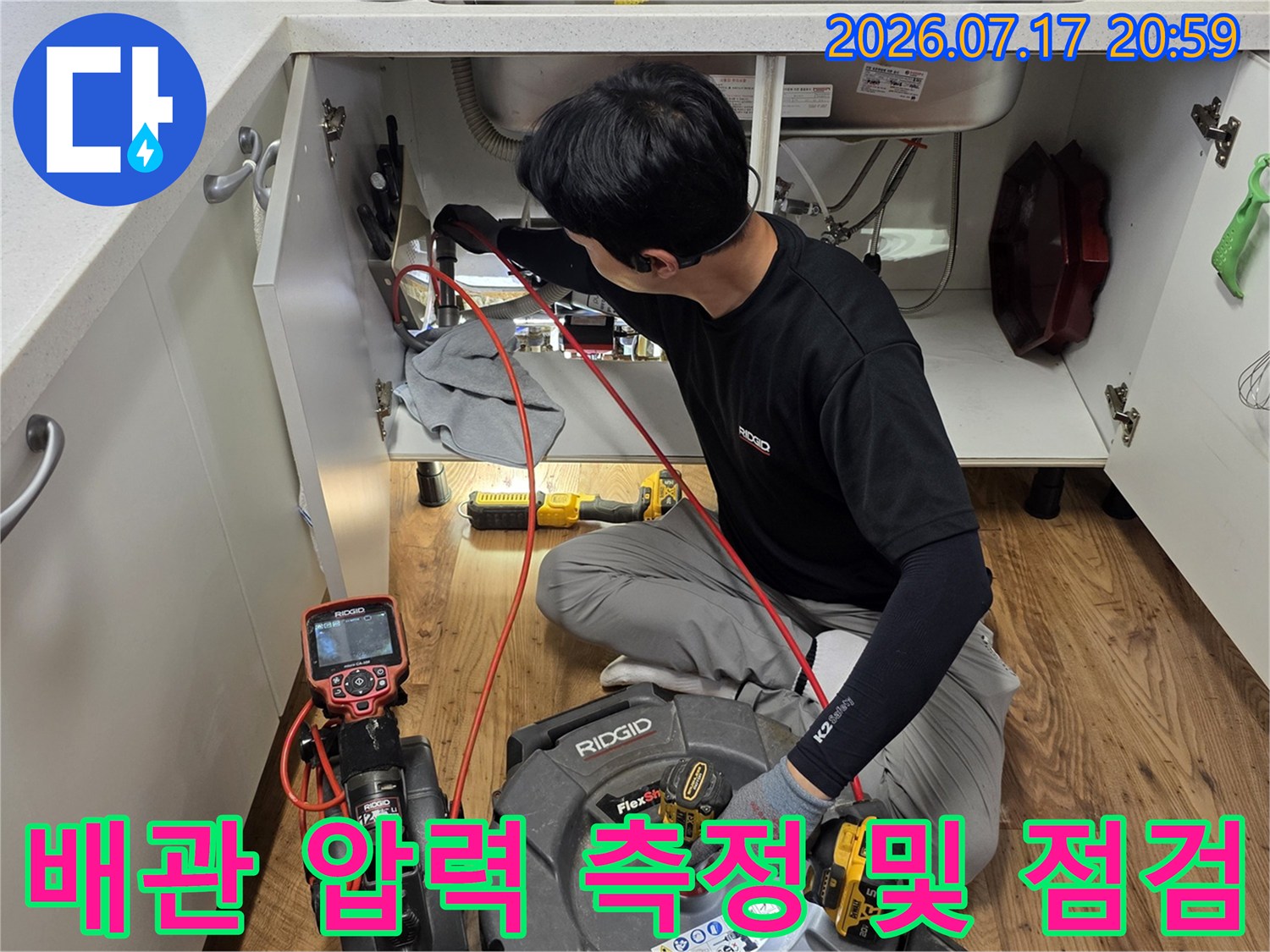 싱크대 하단 영역에서 전문 장비로 배출 경로와 누수 여부를 실시간 확인하는 모습