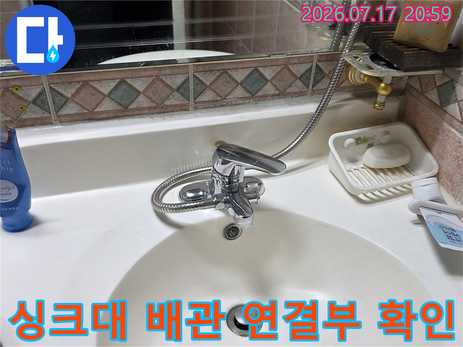 싱크대 하부의 굴곡진 호스와 배수구 입구 점검 모습