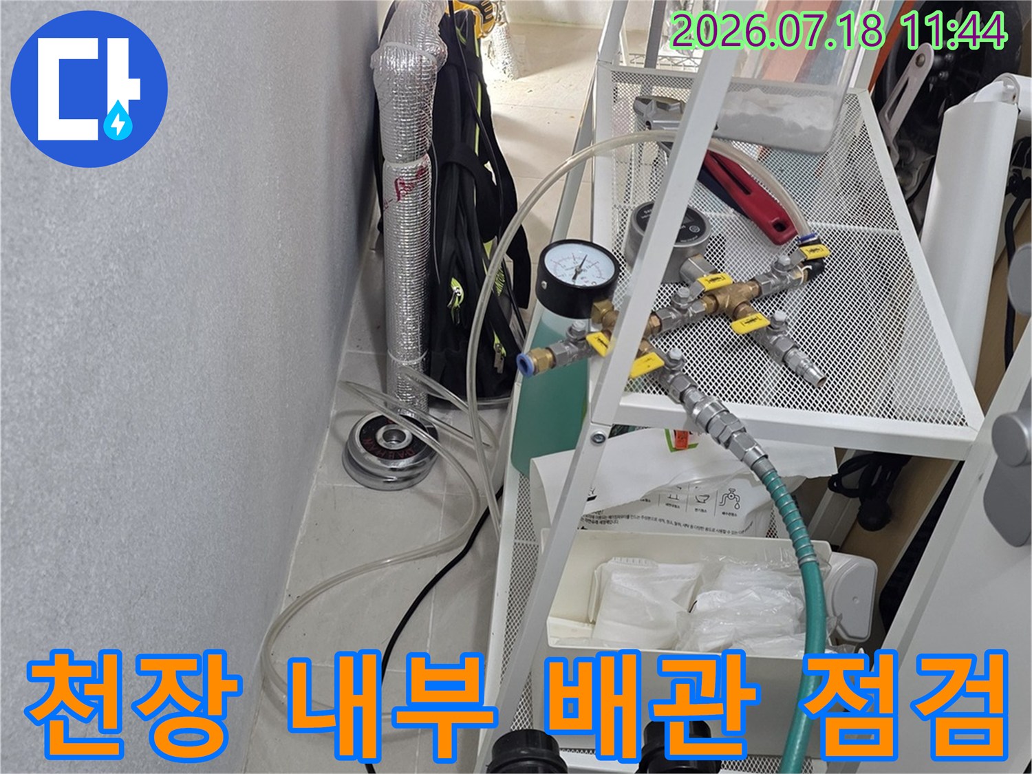 천장 내부에 복잡하게 얽힌 배관들에 공압 게이지를 연결한 모습입니다.