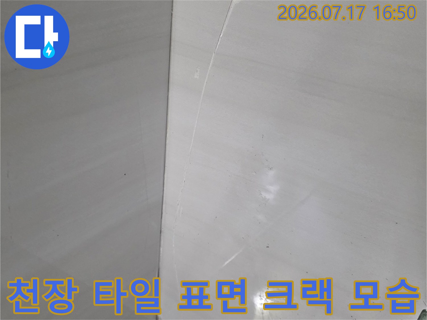밝은 색상의 욕실 천장에 나타난 얇고 긴 균열 부위 근접 사진