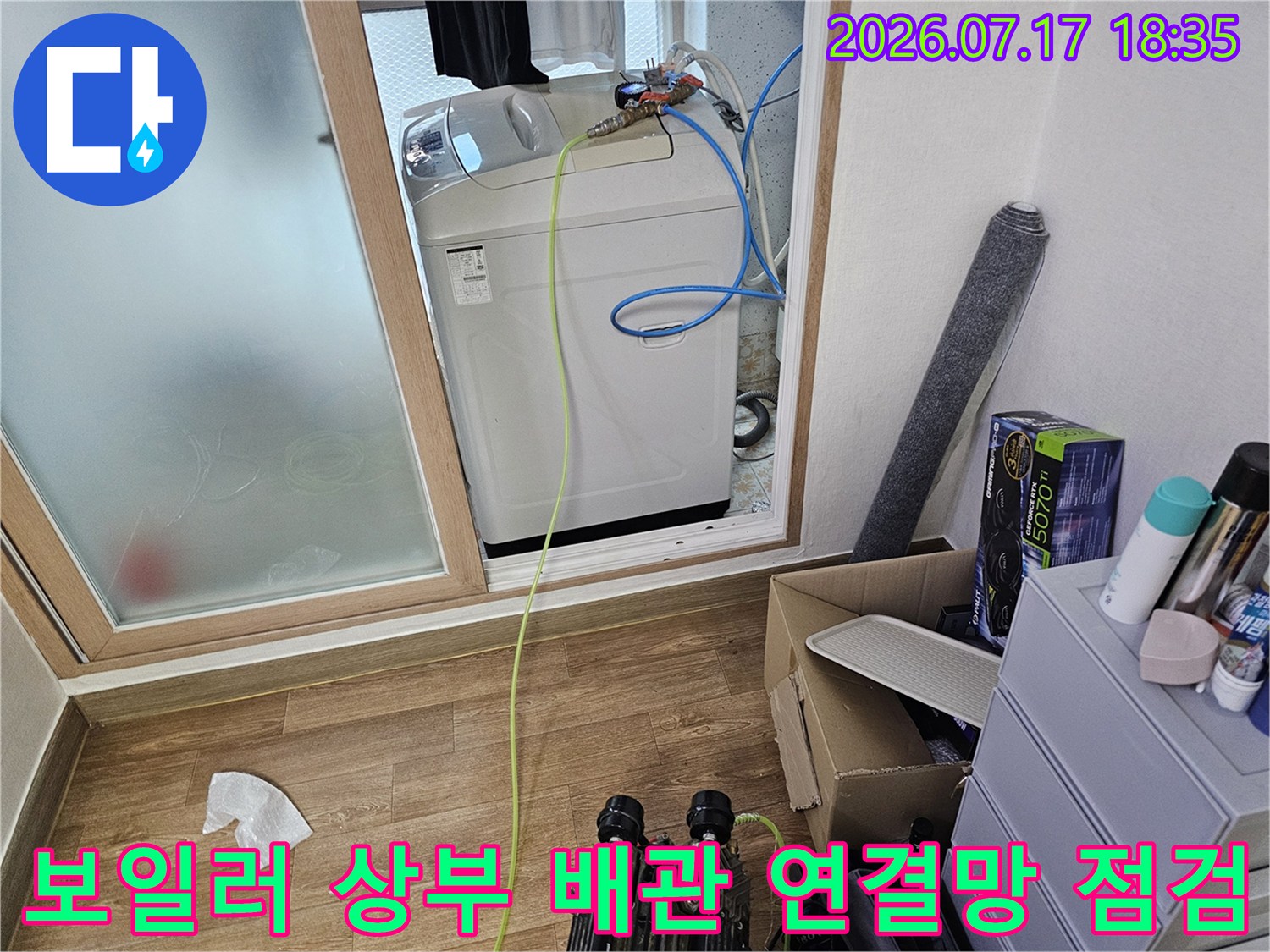흰색 보일러 기기 위에 배치된 파란색과 노란색의 배관-점검 중인 모습