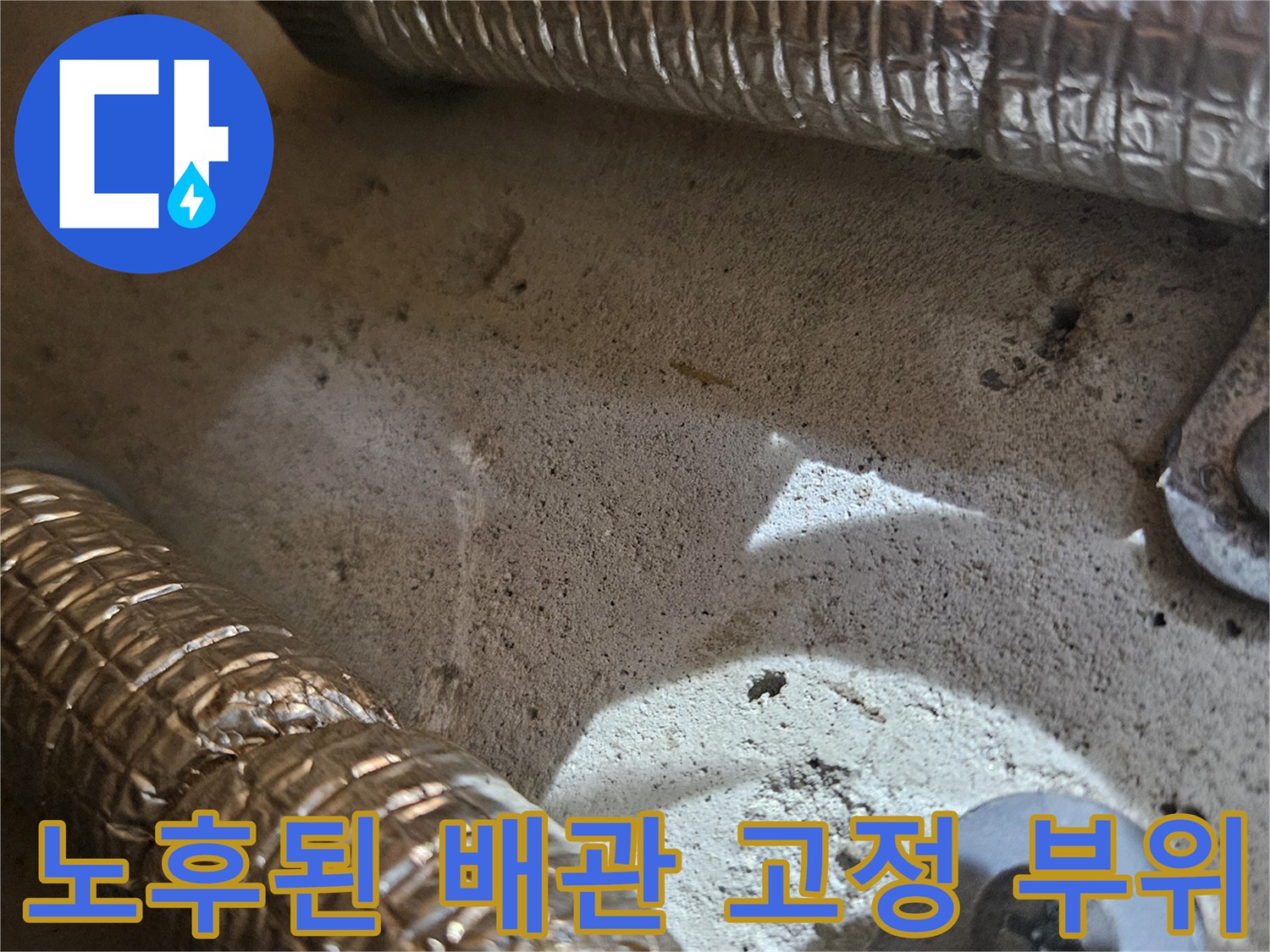 벽면에-고정된-배관의-보온재와-금속-고정장치입니다.