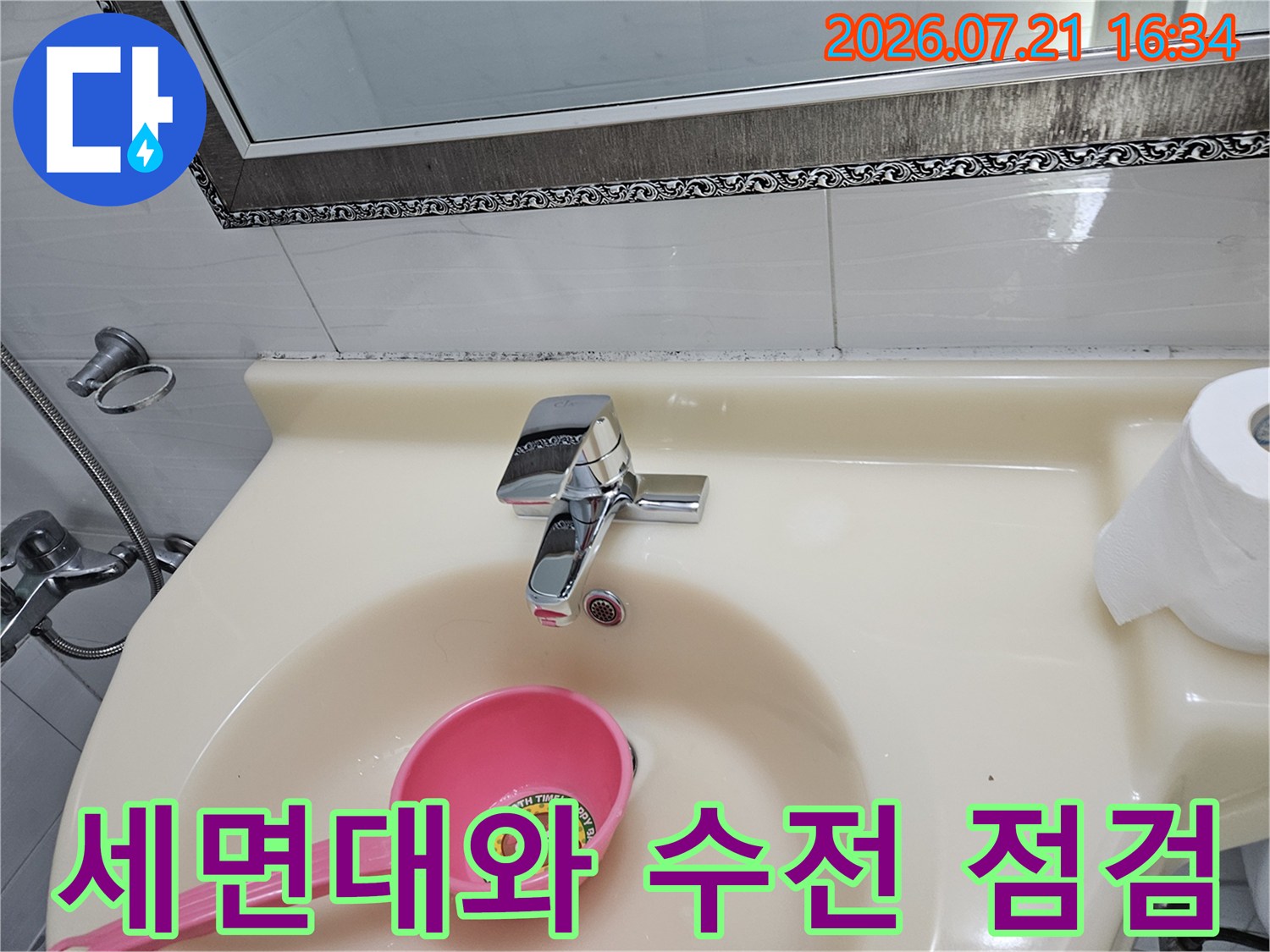 세면대 위에 놓인 분홍색 도구와 수도꼭지 점검 모습