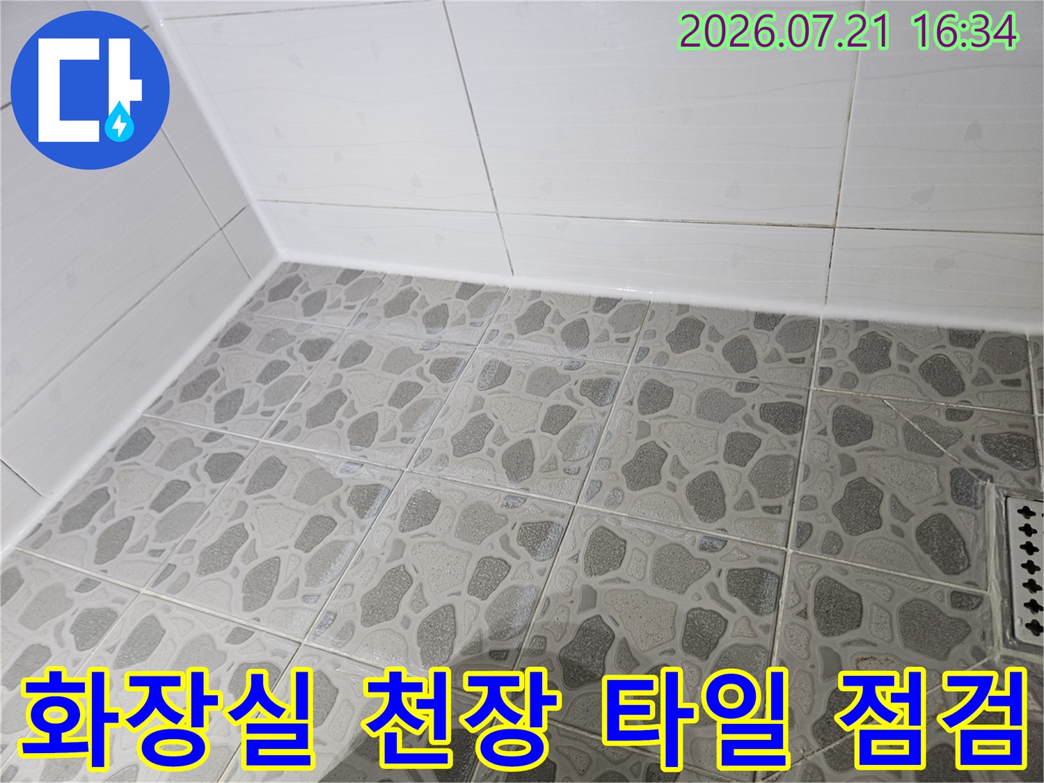 화장실 천장면의 회색 패턴 타일과 하얀 벽체 마감재