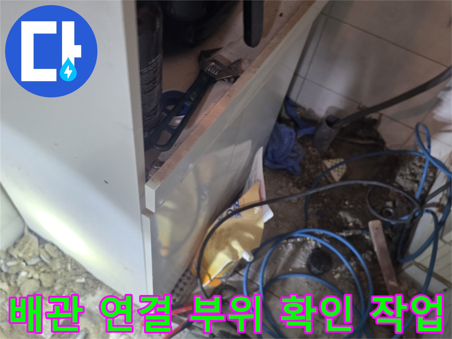 싱크대 밑 좁은 공간에서 진행 중인 배관 상태 정밀 검사 장면입니다.