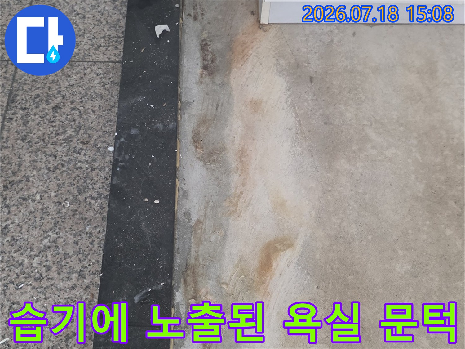 화장실-문턱-부분의-마감재가-물기에-젖어-황갈색으로-변하고-벗겨진-상태