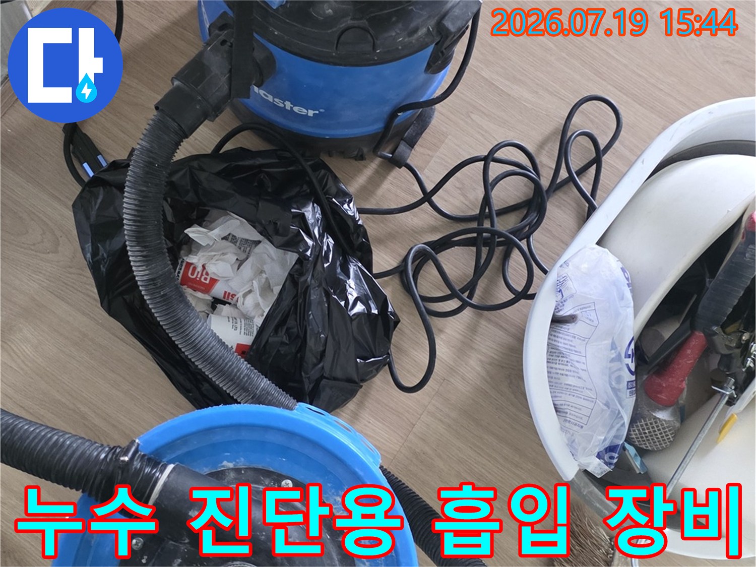 바닥에 놓인 파란색 산업용 청소기와 배관 흡입 장비-누수 점검 준비 과정