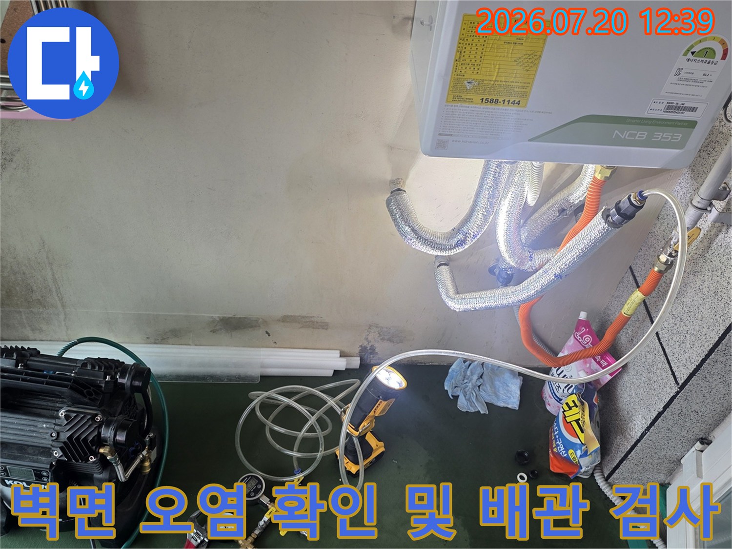 곰팡이가 핀 벽면 아래로 배치된 전문 누수 탐지 장비와 연결 호스들