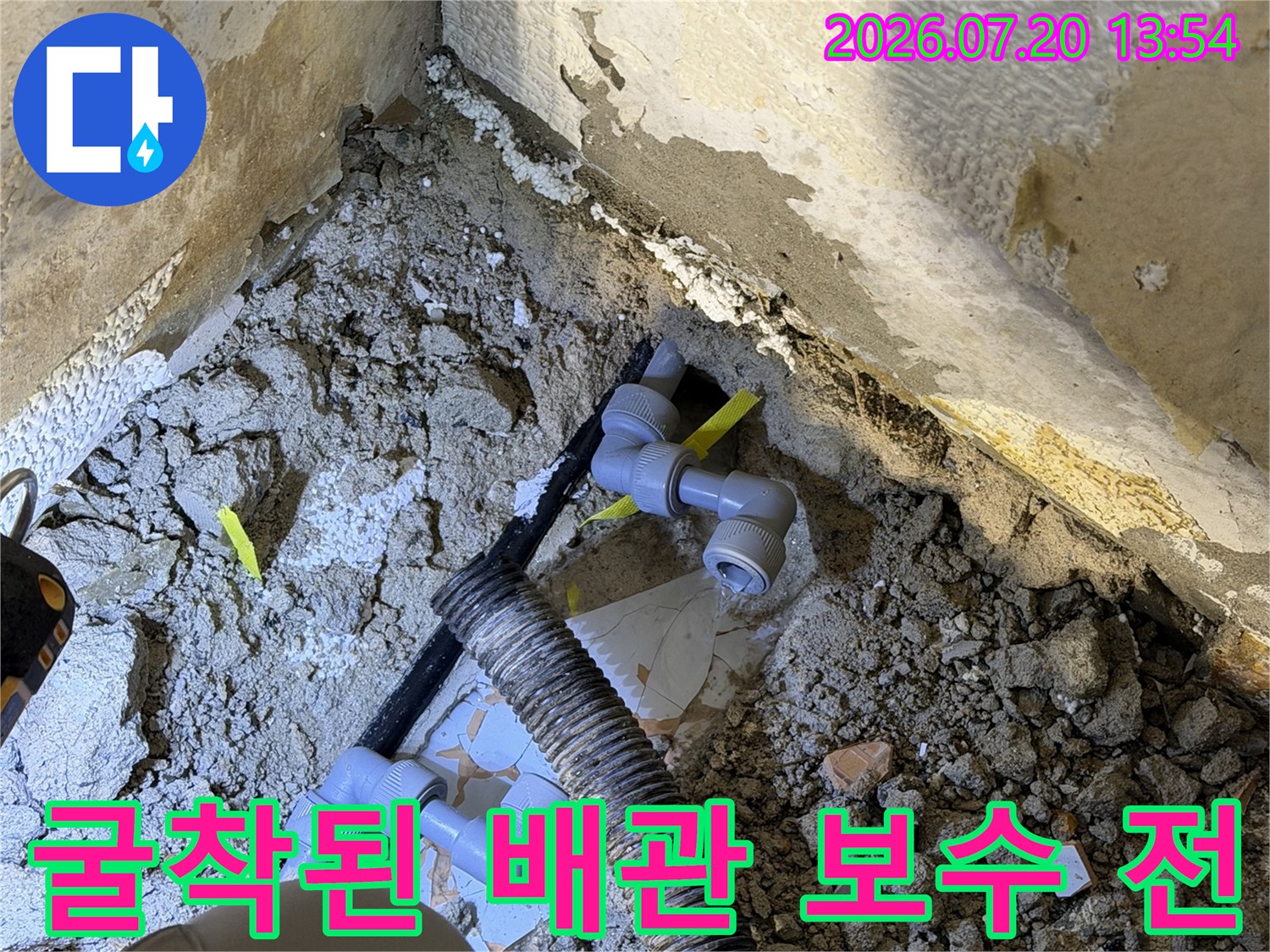 흙더미 속에 드러난 회색 수도 파이프와 엘보우 연결부-누수 지점 사진