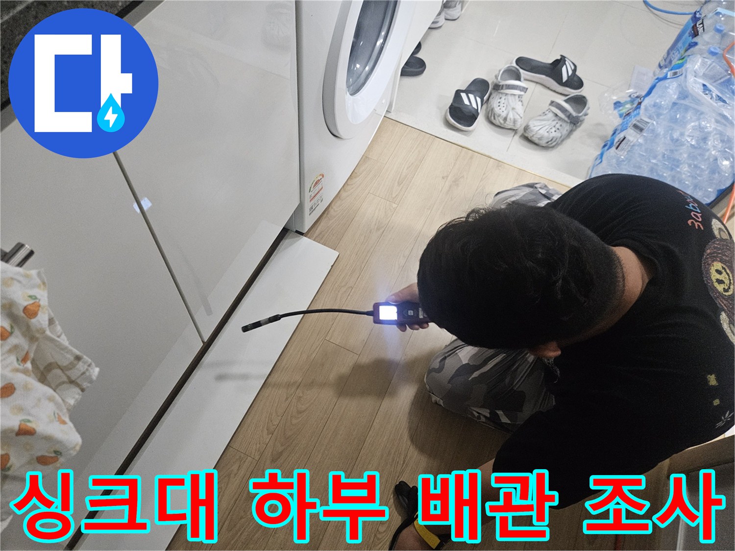 내시경 카메라를 싱크대 밑 좁은 공간으로 투입하여 조사를 수행 중입니다.