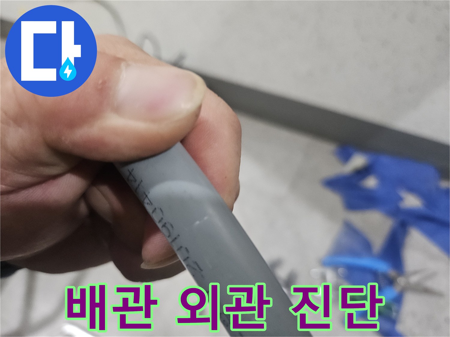 누수 부위를 찾기 위해 엔지니어가 잡고 있는 회색 배관