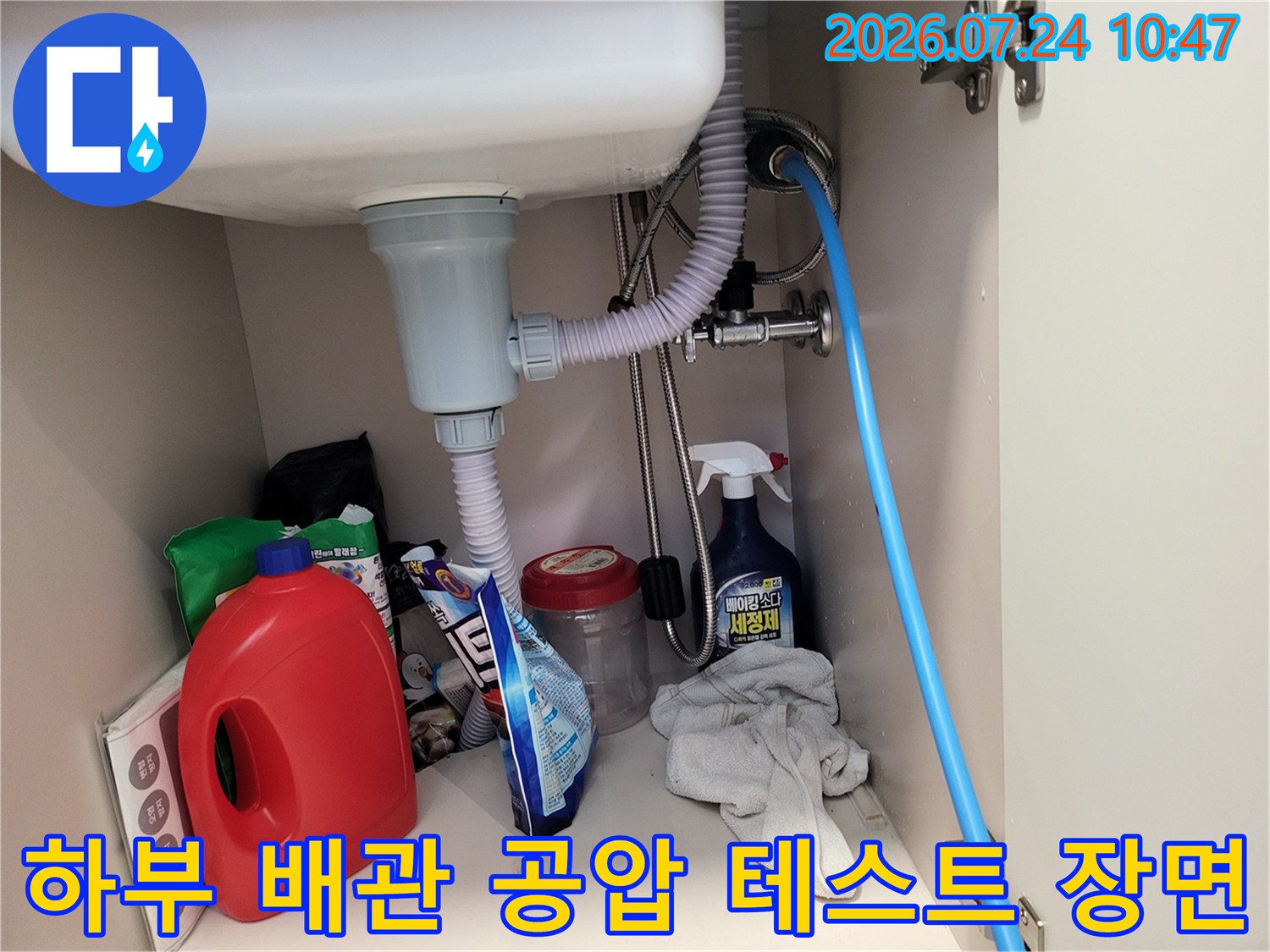 누수 정밀 진단을 위해 싱크대 하부 파이프에 장비를 연결한 모습
