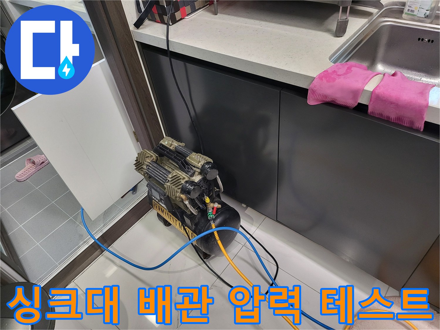 주방 싱크대 하부 배관의 기밀성을 확인하기 위해 공압 테스트기를 설치한 모습입니다.