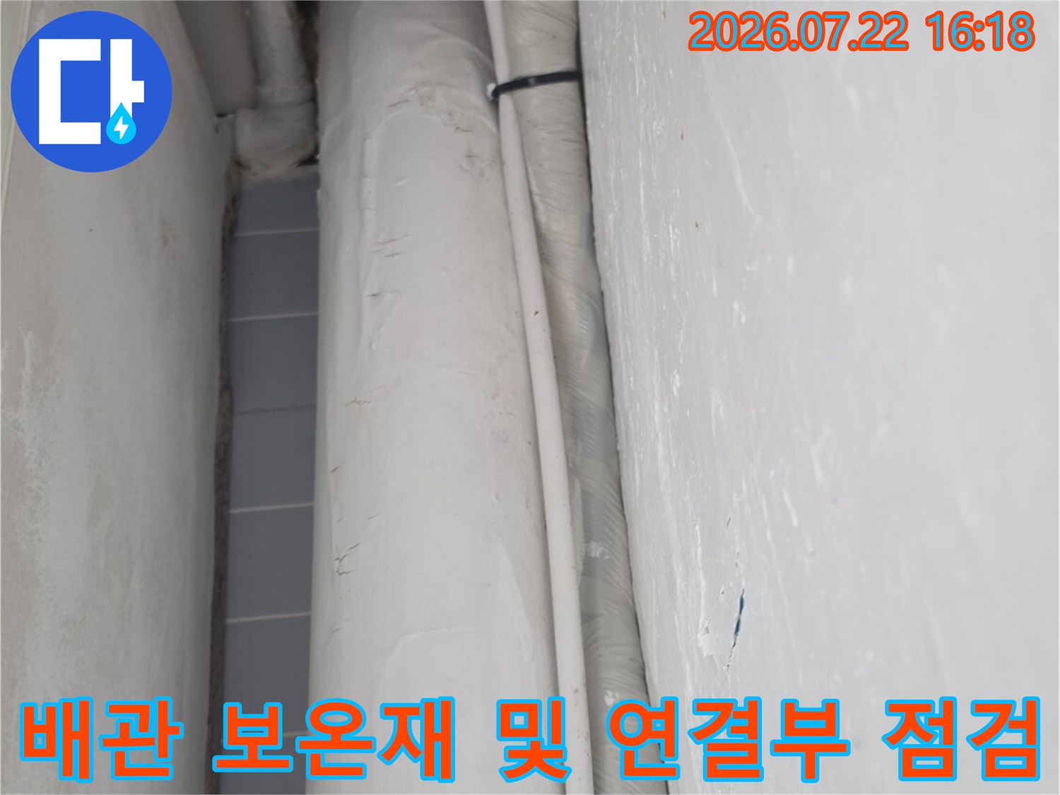 흰색 단열재로 마감된 천장 배관의 굴곡진 연결 부위를 근접 촬영한 사진