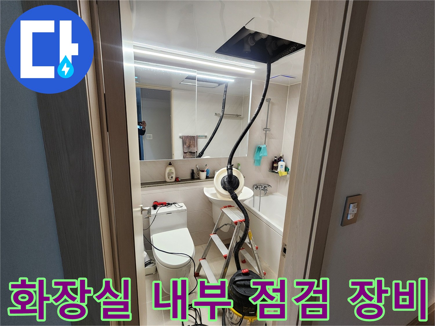 사다리와 청소기가 놓여 있는 화장실 작업 현장 모습
