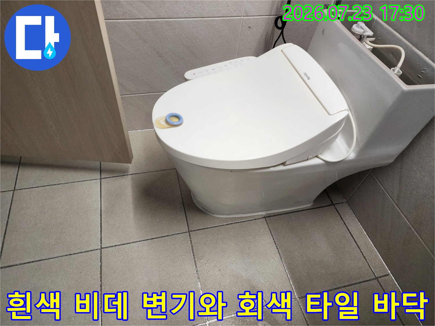 욕실 내부에 설치된 양변기의 전경-바닥 타일과 변기 접합부 중심 사진