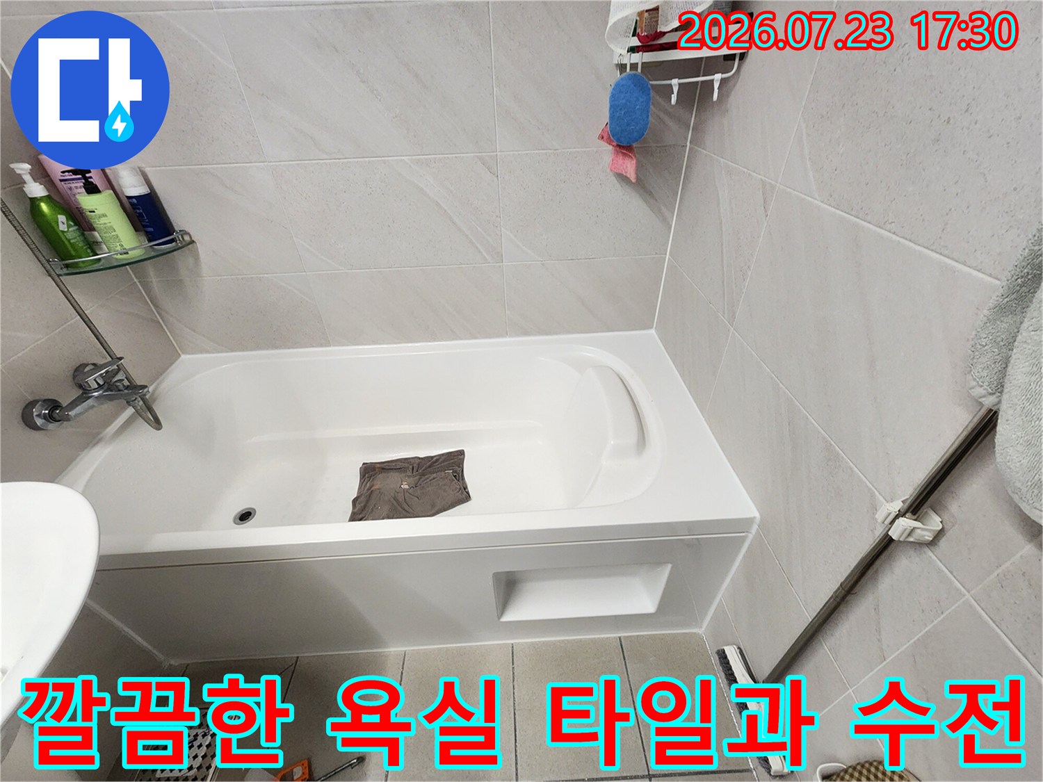 은색 수전과 세면도구가 놓인-화장실 선반과 욕조 전경