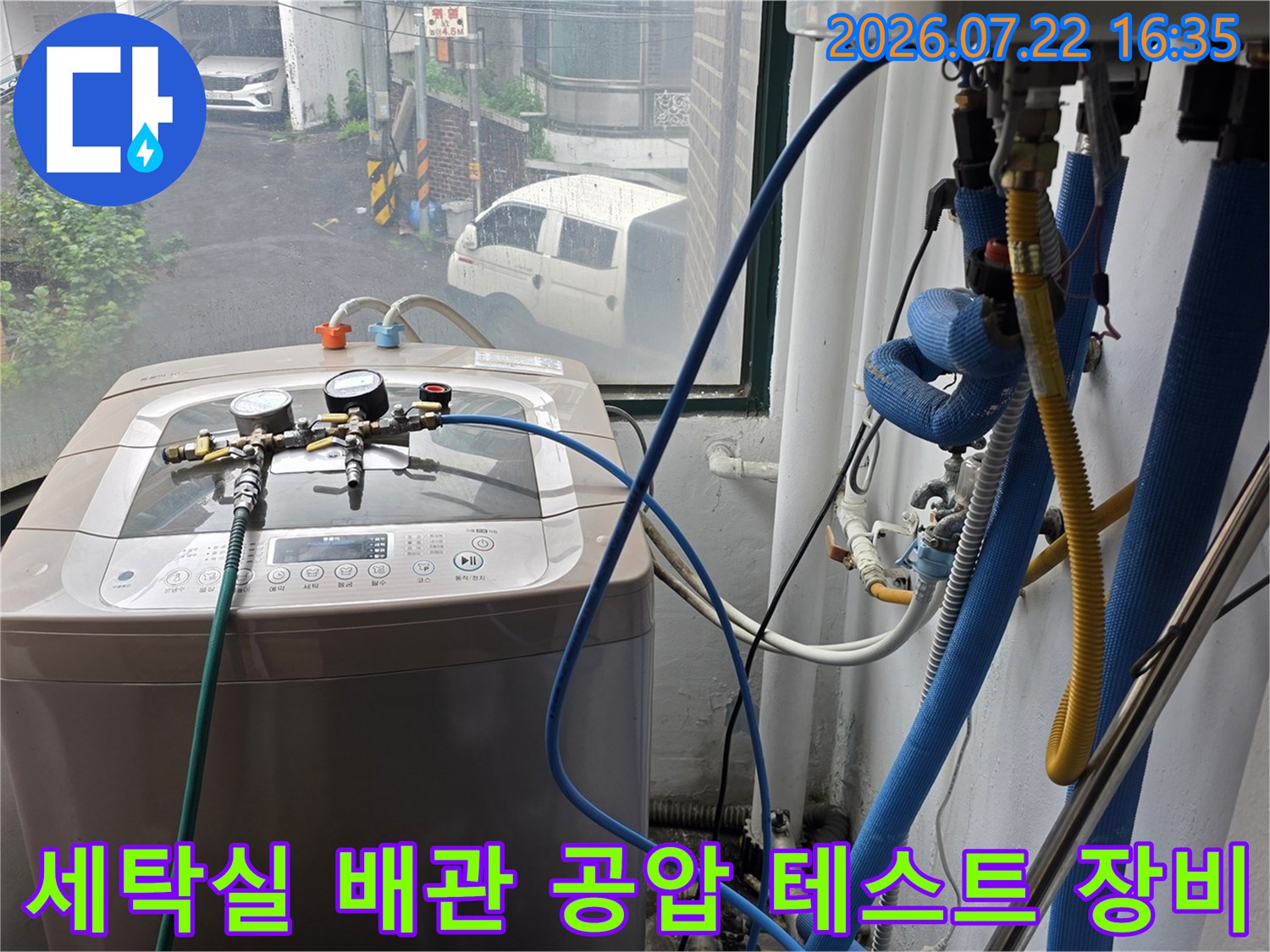세탁기 위에 설치된 정밀 압력 게이지와 파란색 연결 호스-누수 탐지 과정