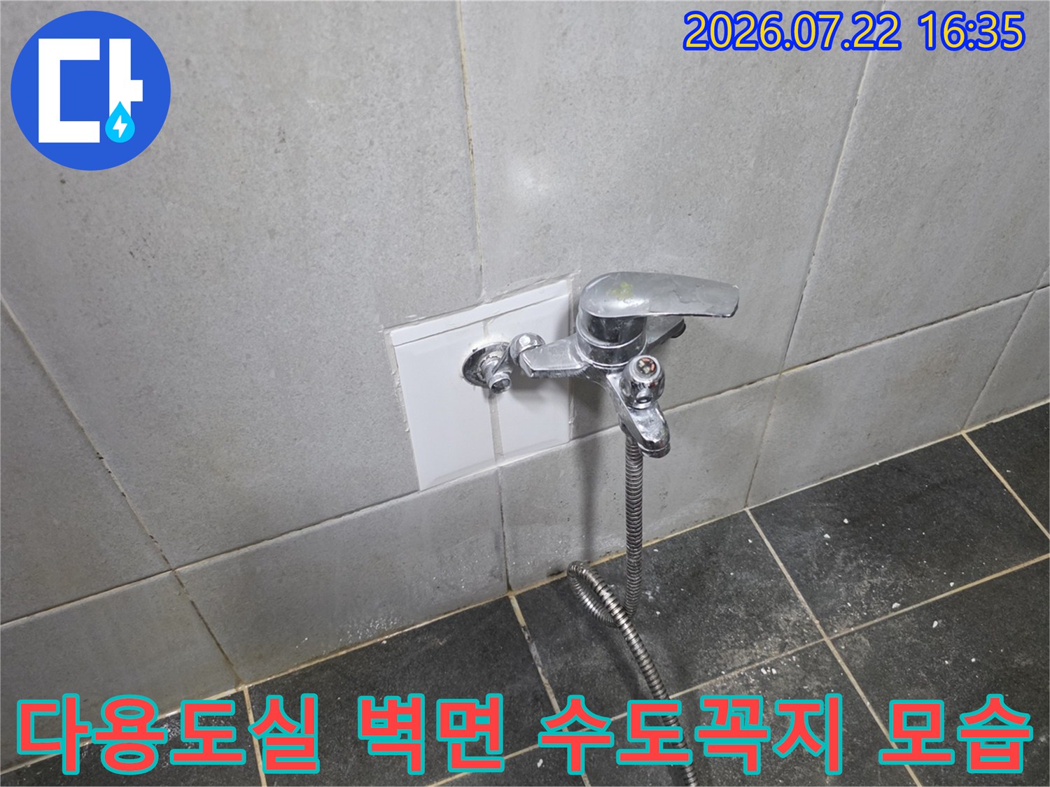 흰색 타일 벽면에 설치된 은색 수도꼭지와 샤워 호스-연결 부위 확인 중