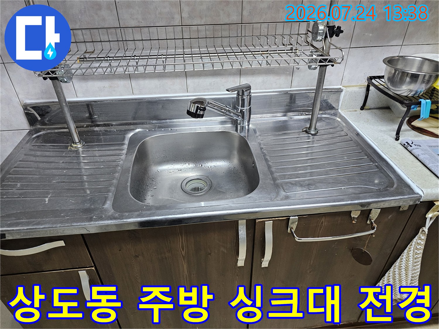 스테인리스 소재의 싱크대 볼과 상단 식기 건조대가 설치된 주방 모습