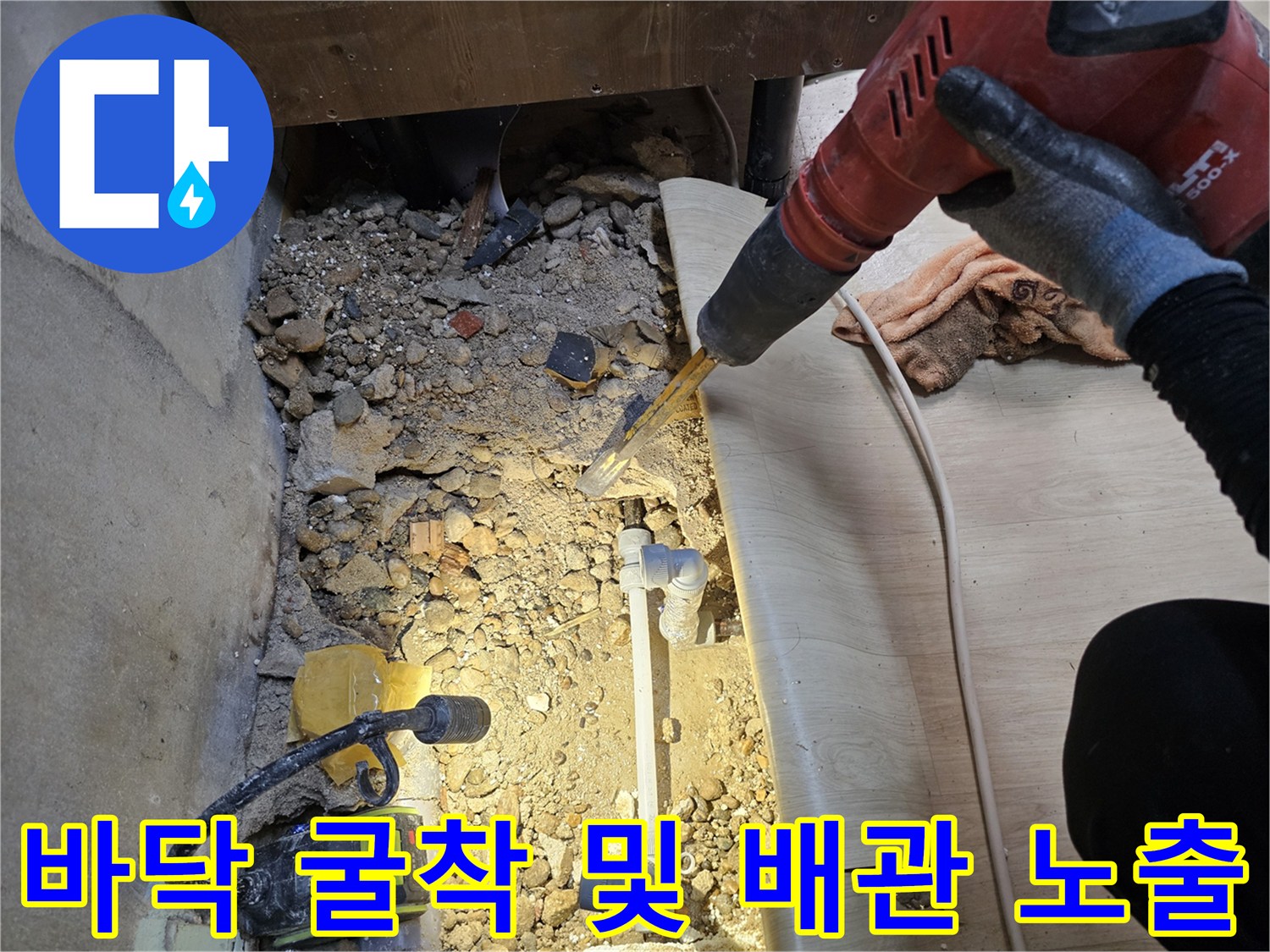 싱크대 아래 바닥을 파내어 드러난 배관과 주변 공사 잔해물