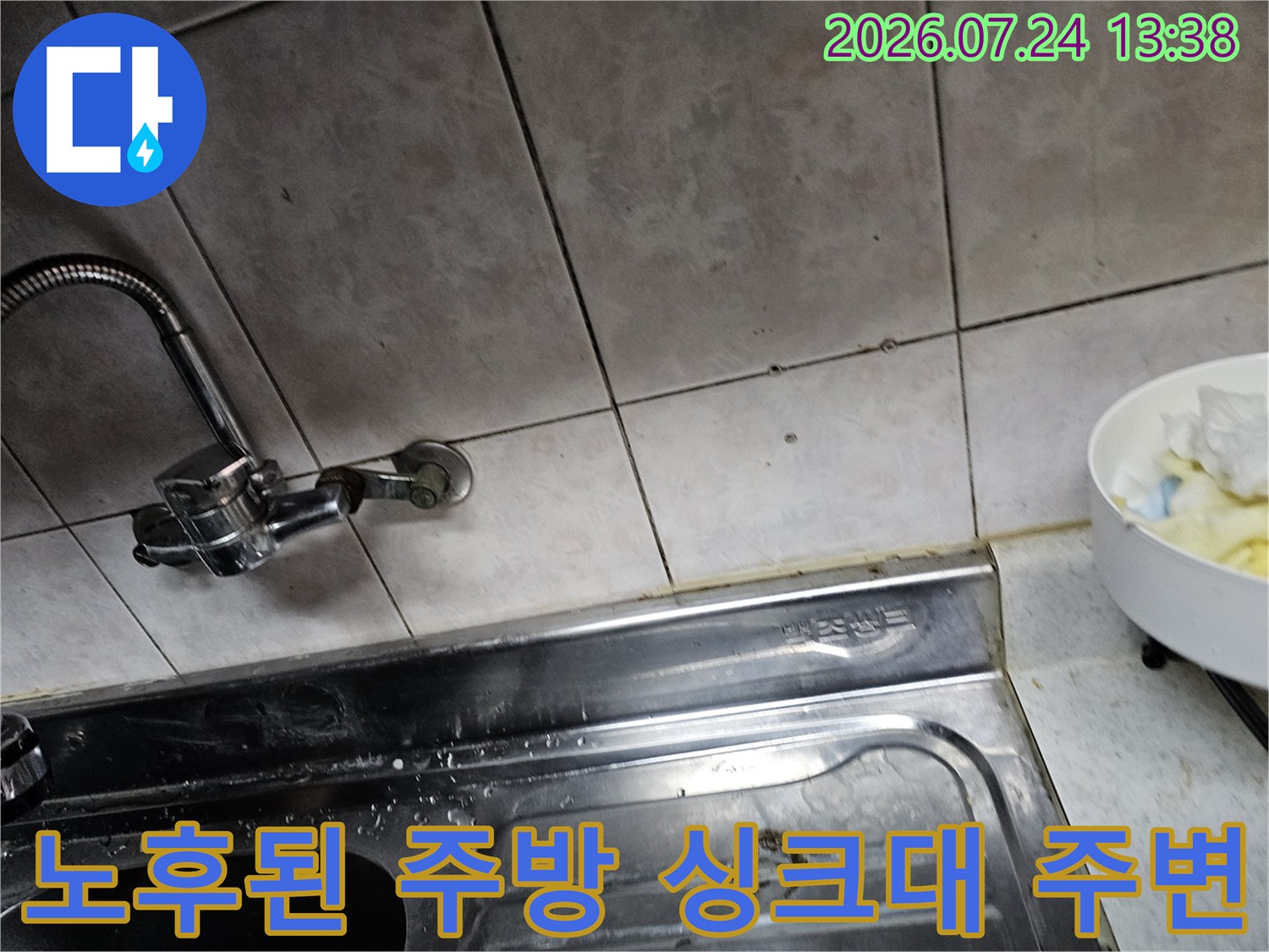 오래된 주방 타일 벽면과 연결된 스테인리스 수전-누수 점검 중