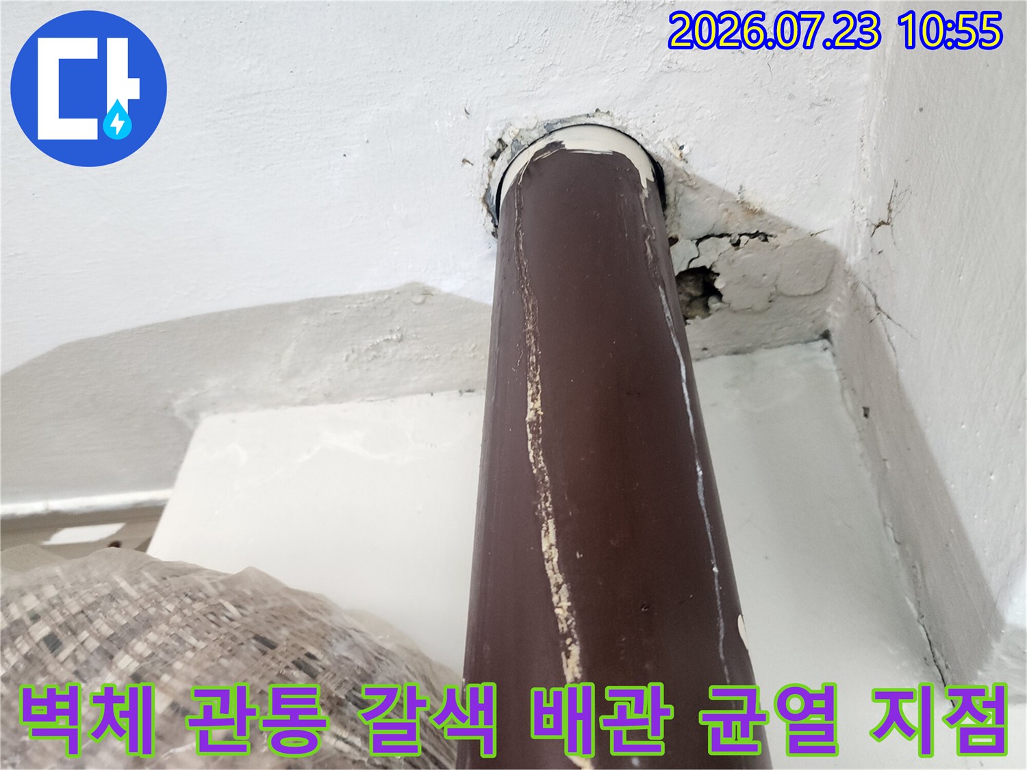 흰색 벽체-갈색 온수 배관 접합부의 심한 균열과 틈새