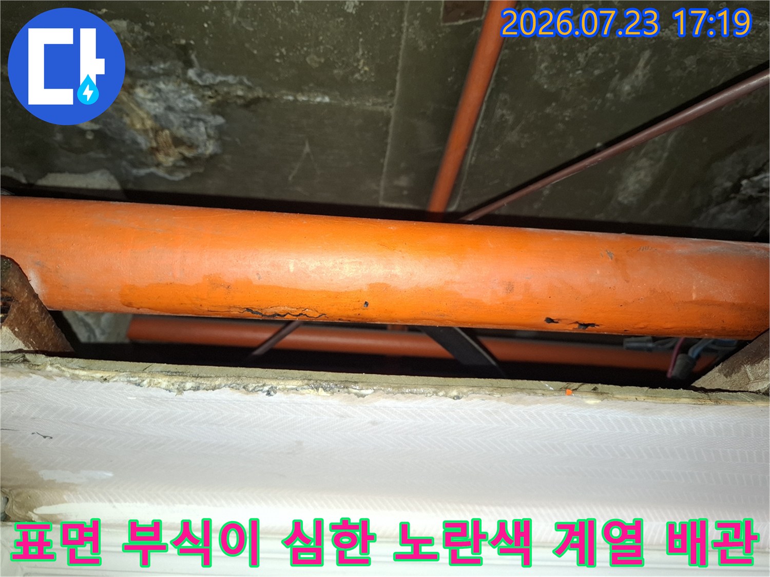 부식으로 인해 표면이 거칠어지고 누수가 진행 중인 오렌지색 배관 사진