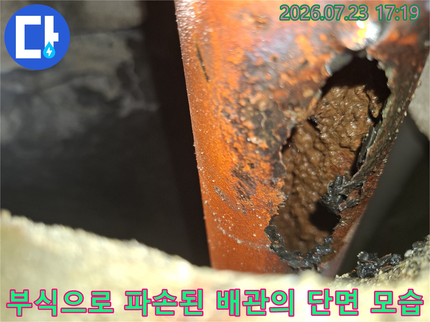 심한 부식으로 인해 외벽이 뜯겨 나가 구멍이 생긴 오렌지색 배관-누수 지점