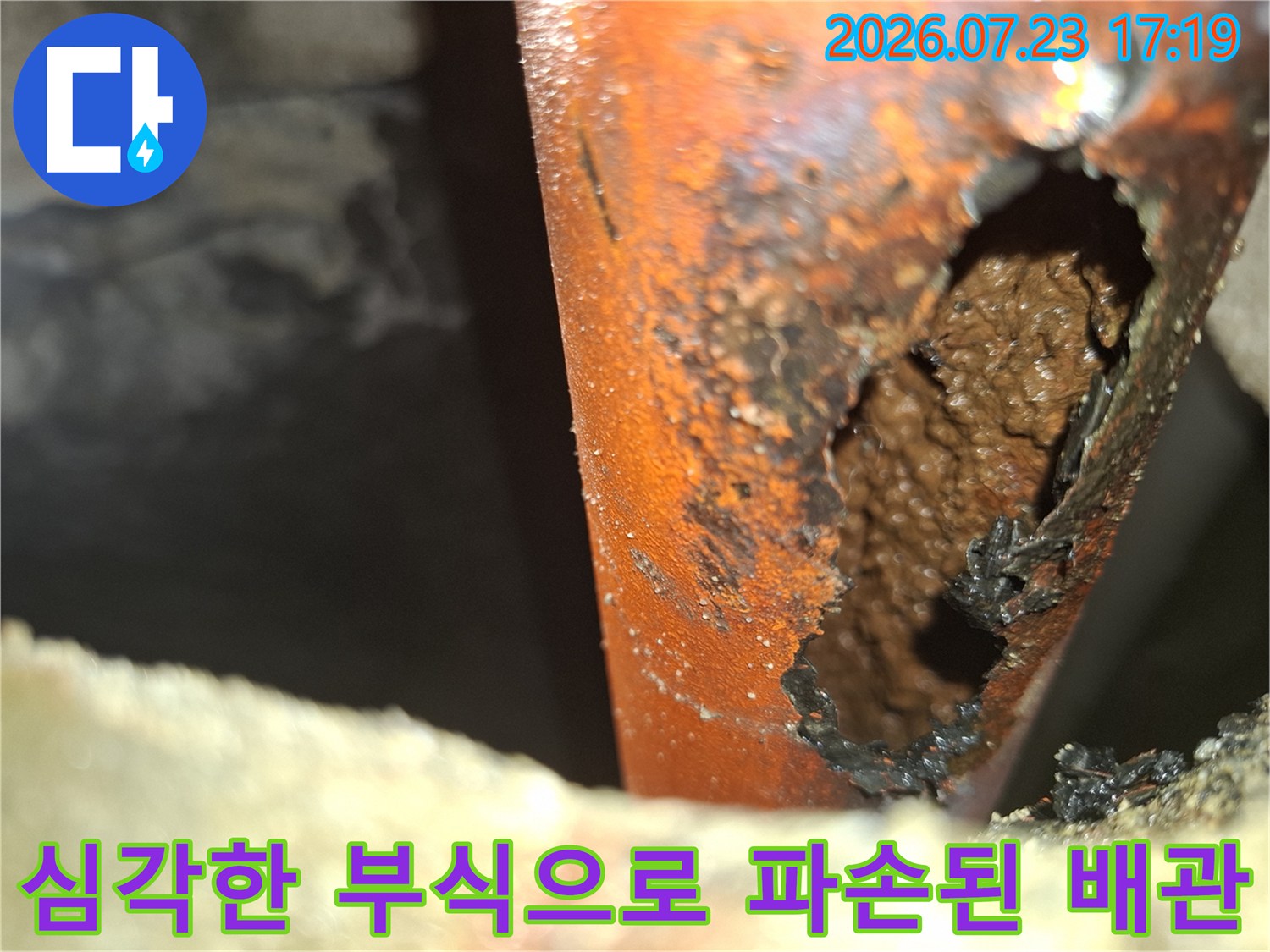 오렌지색 배관의 표면이 삭아 없어져 내부가 드러난 누수 지점 사진