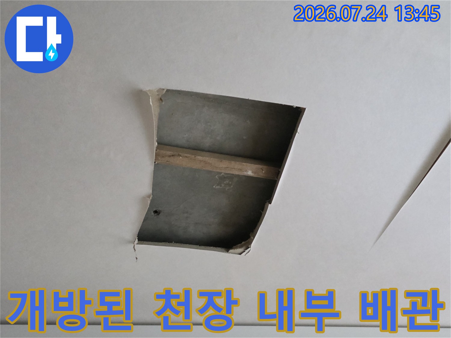 거실 천장 내부에 노출된 배관과 점검 구역을 촬영한 사진