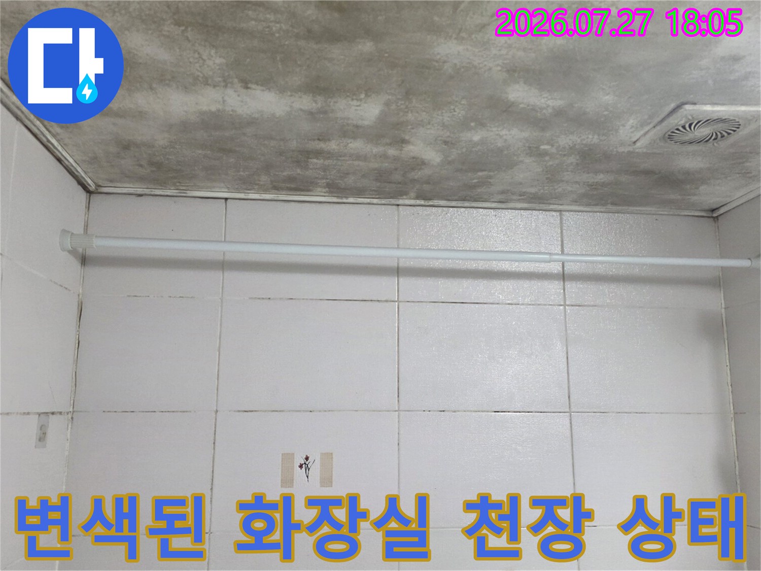 샤워 커튼봉이 설치된 욕실 내부에서 누수로 인해 지저분해진 천장면의 모습