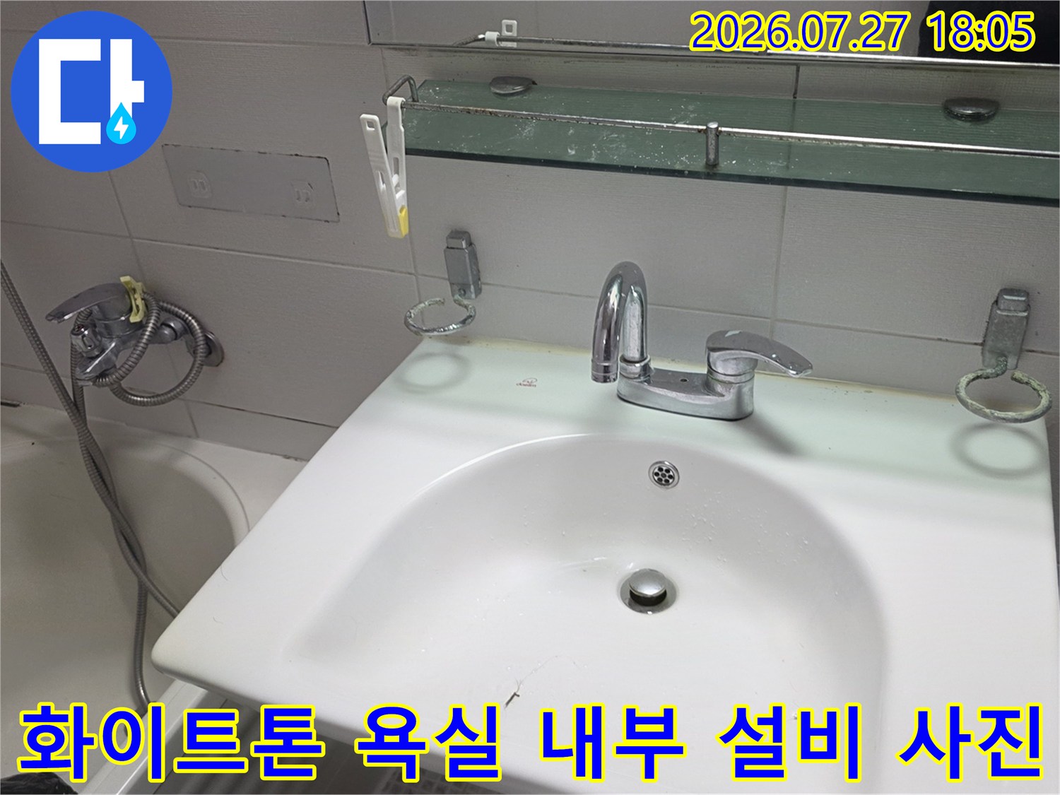 세면대 위 거울 선반과 수전-왼쪽의 샤워기 헤드가 설치된 모습