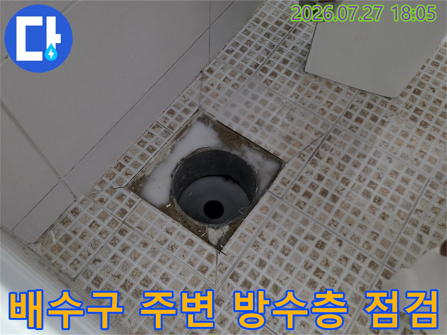 타일-바닥에-설치된-배수관-주변으로-물이-고여있는-현장-사진