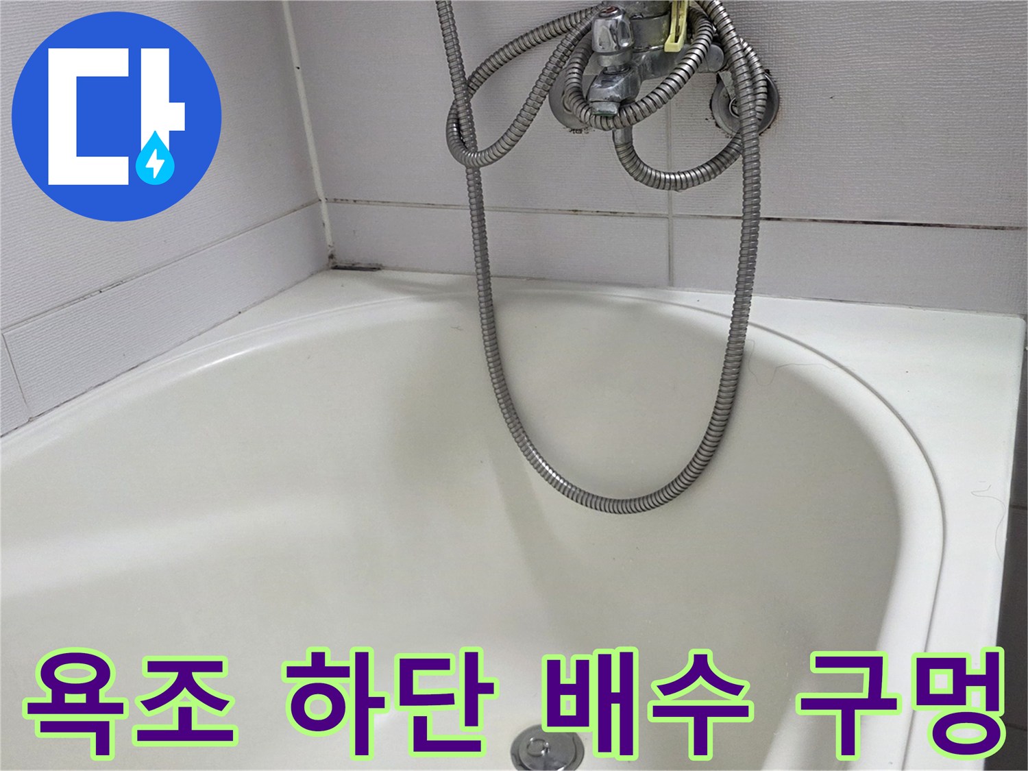 하얀색 욕조 바닥의 배수구와 샤워기 호스