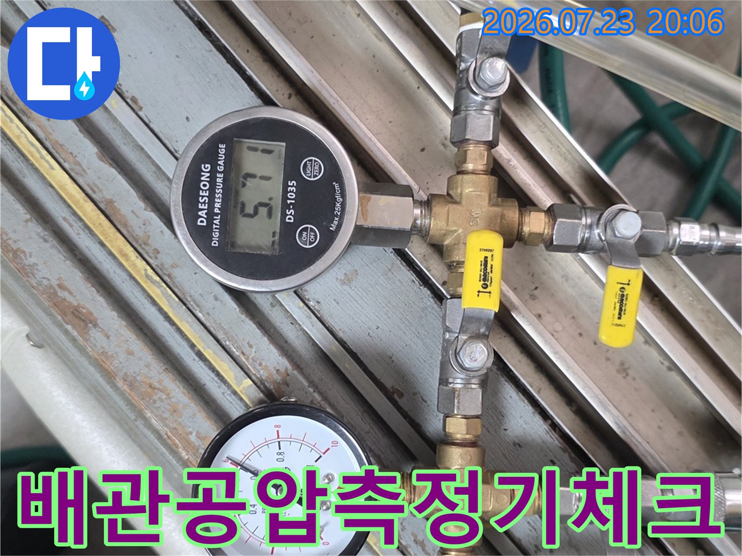 공압 테스트를 위해 연결된 두 개의 압력계와 금속 배관 시스템