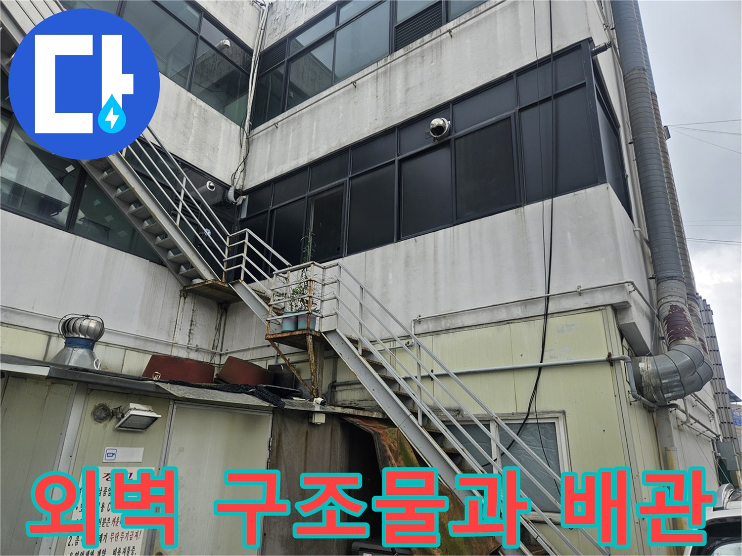 건물 외곽의 금속 난간 및 외부 노출 배관의 모습
