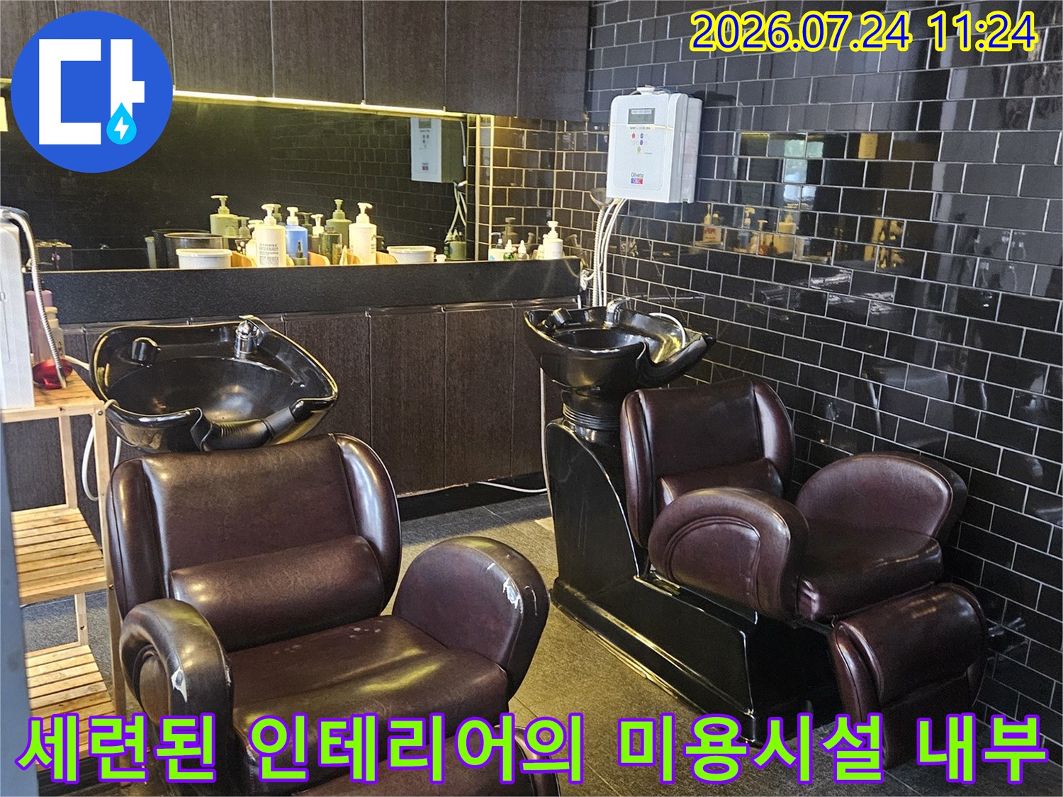 고급스러운 타일 마감과 샴푸대가 배치된 매장 실내